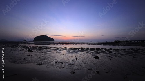 Sunset over tropical white sand beach with tidal flats and island silhouette