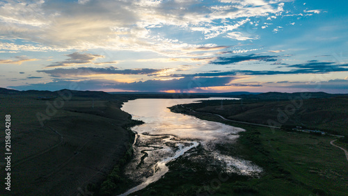 Beautiful sunset scenery of Xilingol National Wetland Park in Inner Mongolia. Golden twilight glow over wetland water surface, natural wetland ecological landscape at dusk.