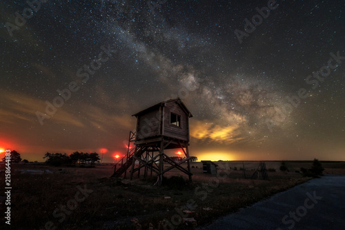 Bild auf Leinwand Milky way galaxy shining over an old wooden control tower at an abandoned airfie