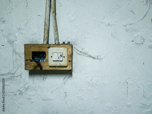 Fotografía Old broken electrical switch with dangerous exposed wires on a dirty unmaintaine