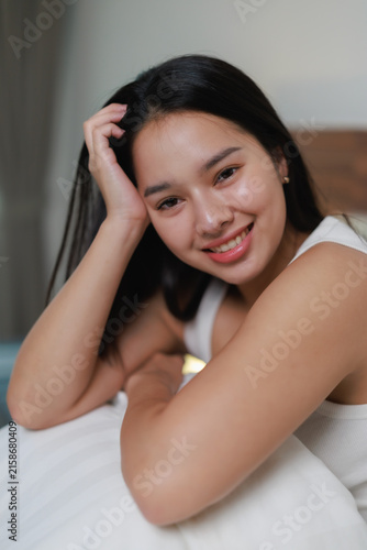 Quadro su tela Young asian woman smiling and relaxing on a comfortable bed in the bedroom, havi