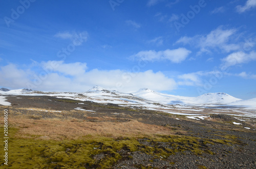Icey snow capped mountains in a field of black rocks