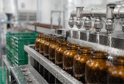 Automated washing of amber glass bottles on a conveyor belt in a factory