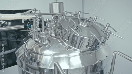 Production facility, shining metal machinery is hard at work. Pipes, valves, and gauges. Technology and automation. Factory machine at work. Close-up in 4K