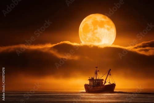 Fishing trawler under a large orange moon