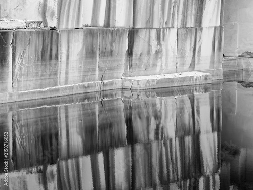 wall of marble blocks reflecting in a lake in the Cava Valsora area in the province of Carrara