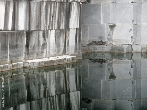 wall of marble blocks reflecting in a lake in the Cava Valsora area in the province of Carrara