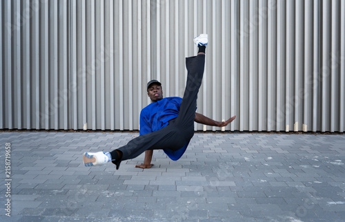 Konstfotografi Male dancer performing breakdance move on urban street, expressing freedom and d