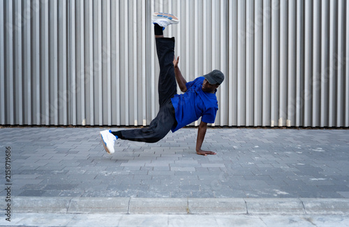 фотографія Male breakdancer performing dynamic move on urban street, showcasing agility and