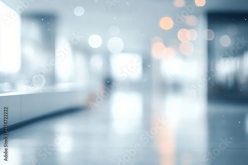 blurred modern interior lobby with glossy floor reflections, soft bokeh lights, floating particles and a distant solitary silhouette conveying a calm, dreamy, ethereal mood