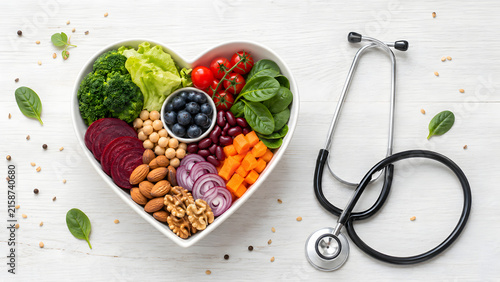 Heart shaped bowl with healthy vegetables and stethoscope for medical nutrition concept