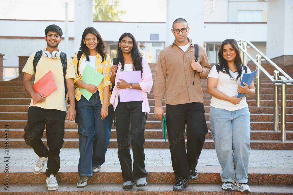 Fototapeta premium Diverse students walking down university stairs learning together
