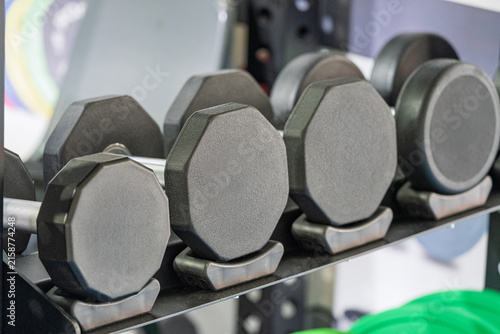 Konstfotografi neatly arranged professional dumbbells on gym weight rack