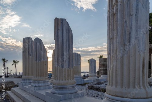 Fotografie Massive marble columns of ancient Temple of Athena illuminated by setting sun in backlight on coast