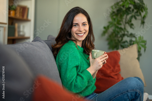Foto Woman enjoying coffee on couch feeling relaxed and happy