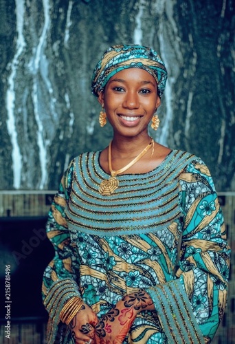 Portrait of a Smiling African Woman in Traditional Teal Ankara Dress with Headwrap and Henna