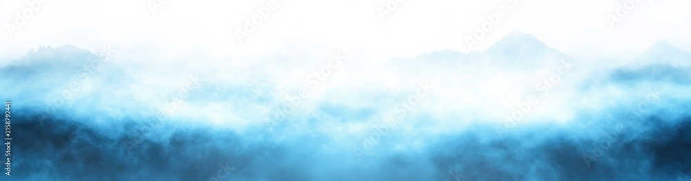 Obraz premium serene misty mountain silhouettes with layered blue fog and a soft glowing horizon