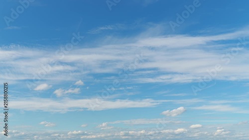 Beautiful abstract background featuring thin wispy cirrus clouds drifting across a bright blue sky in a cinematic timelapse motion with soft natural lighting and airy atmosphere