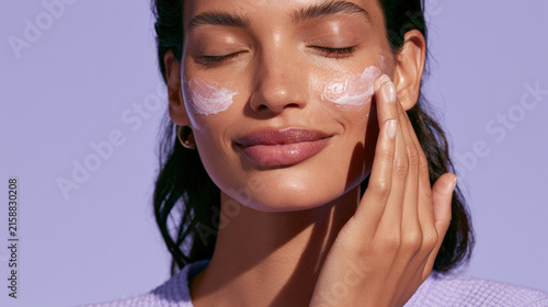 Female model applying overnight repair mask with closed eyes and calm expression, showcasing skincare routine and hydration