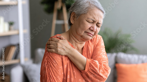 Senior Asian woman shoulder pain discomfort at home