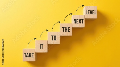 Wooden blocks with the text take it to the next level on yellow background