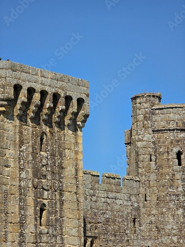 Cuadro en lienzo Stone castle walls, battlements, machicolations, and turrets under a clear blue