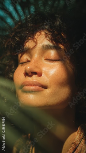 Close-up portrait of a woman with eyes closed and a peaceful smile experiencing pure bliss surrounded by lush green nature perfect for mindfulness wellness concept