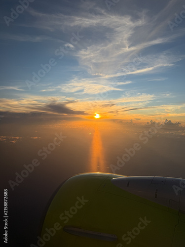 Airplane Wing Above the Clouds at Sunset, Aerial View from Aircraft Window
