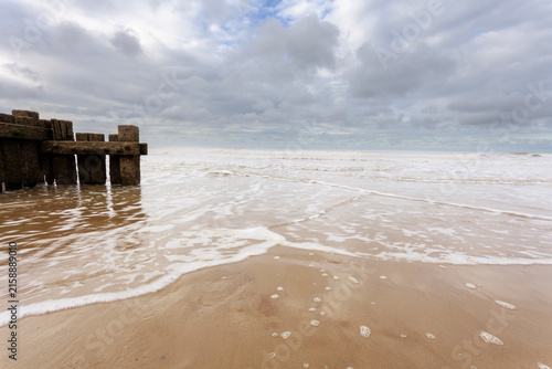 Canvas Print Waves and Wooden Sea Groyne on Sandy Overstrand Beach in Norfolk UK