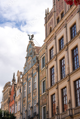 Fotografie Ornate facades and decorated gables of historic tenement houses stand under a cloudy sky in the famous Long Market area of Gdansk, Poland