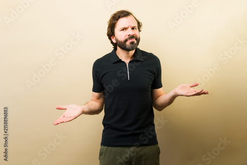 Quadro su tela Confused man shrugging shoulders, making a gesture of uncertainty or not knowing