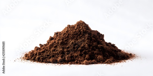 A mound of dark brown coffee grounds rests against a bright white background.