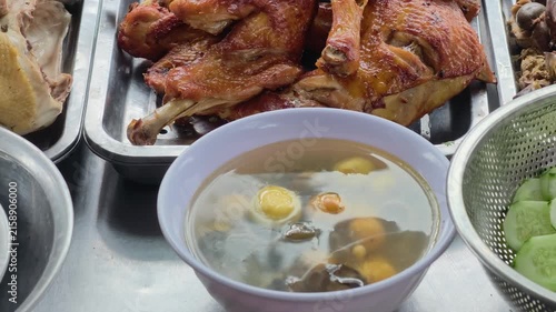 POV from inside a counter: Close-up of boiled chicken parts, grilled chicken drumsticks, young eggs, and giblets at a traditional Vietnamese local food stall in Phu Yen.