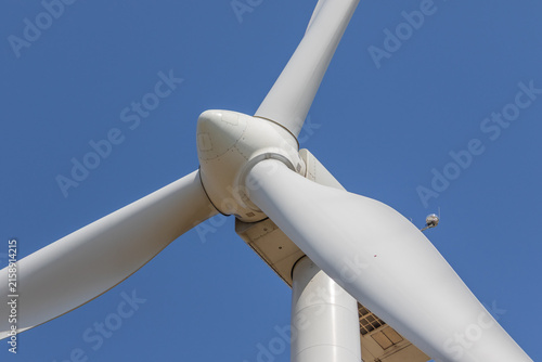 Close-up of wind turbine rotor and blades against blue sky – renewable energy technology photo