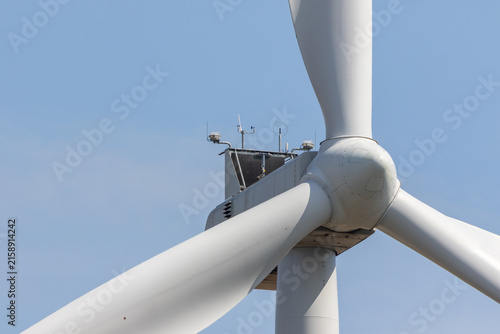 Close-up of wind turbine rotor and blades against blue sky – renewable energy technology photo