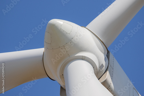 Close-up of wind turbine rotor and blades against blue sky – renewable energy technology photo