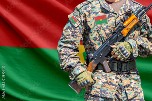 Burkina Faso flag with soldier holding assault rifle