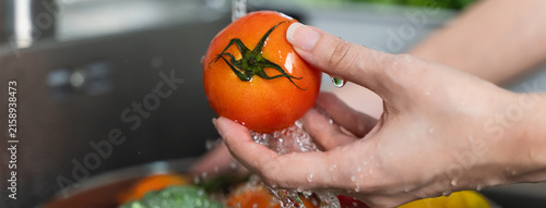 Close up of hands people washing vegetables by tap water at the sink in the kitchen to clean ingredient prepare a fresh salad.