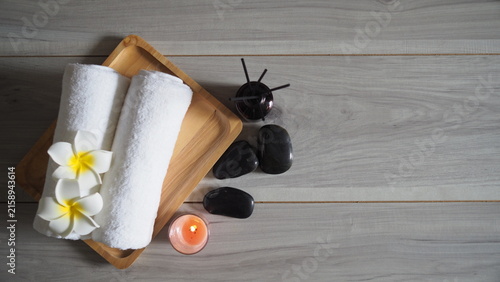 Photography Spa treatment setting featuring white rolled towels adorned with plumeria flower