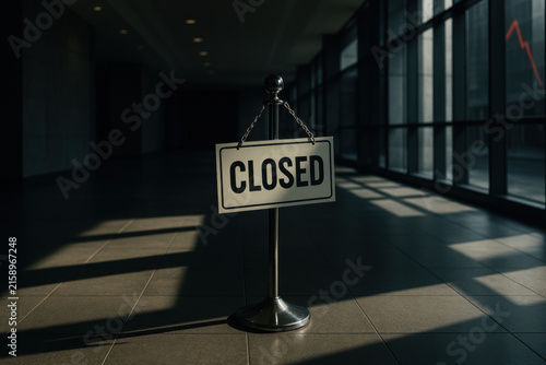 Closed sign in empty corporate lobby with dramatic lighting and shadows, symbolizing financial downturn and business closure in modern office environment