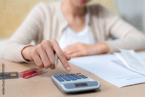 Konstfotografi Woman calculating household expenses with calculator, credit cards and financial documents at home, representing budgeting, debt management, monthly bills, payments, personal finance planning