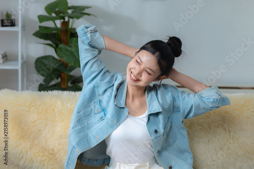 Принти на полотні Happy young woman relaxing and stretching on sofa at home, enjoying a comfortable break with positive mood, wellness, stress relief, leisure, self care and healthy lifestyle concept
