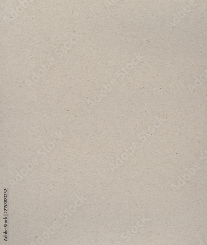 Recycled cardboard paper texture background with subtle fibers and specks creating a natural and rustic backdrop for design projects and crafts.