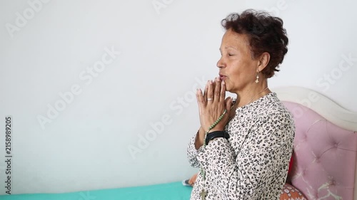 Mature Woman Praying and Giving Thanks with Raised Hands at Home