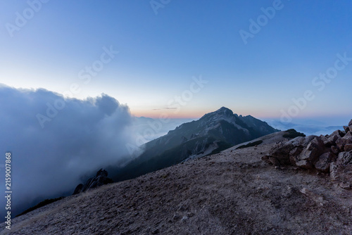 Twilight sky over jagged granite peak and sea of clouds in Japan Alps