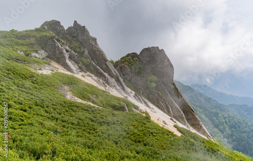 Jagged granite rock spires rising along foggy mountain ridge
