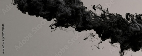 Wisps of black ink swirl and diffuse in muted grey space