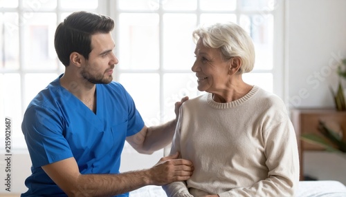 Nurse speaking kindly with elderly patient in comfortable healthcare room, compassionate care concept