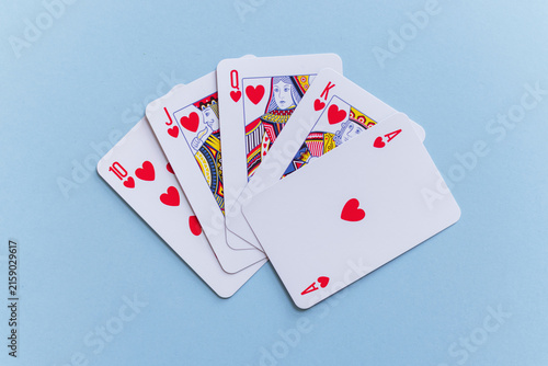 Bild auf Leinwand Royal flush hand of heart playing cards fanned out on a pastel light blue background
