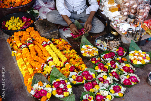 India. Uttarakhand. Haridwar. A man is making ritual offerings from marigold and rose flowers and leaves